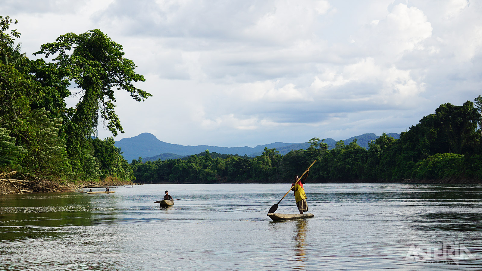 Reis langs de met jungle omzoomde waterwegen waar bootmensen, rechtopstaand in hun slanke boomstamkano’s peddelen